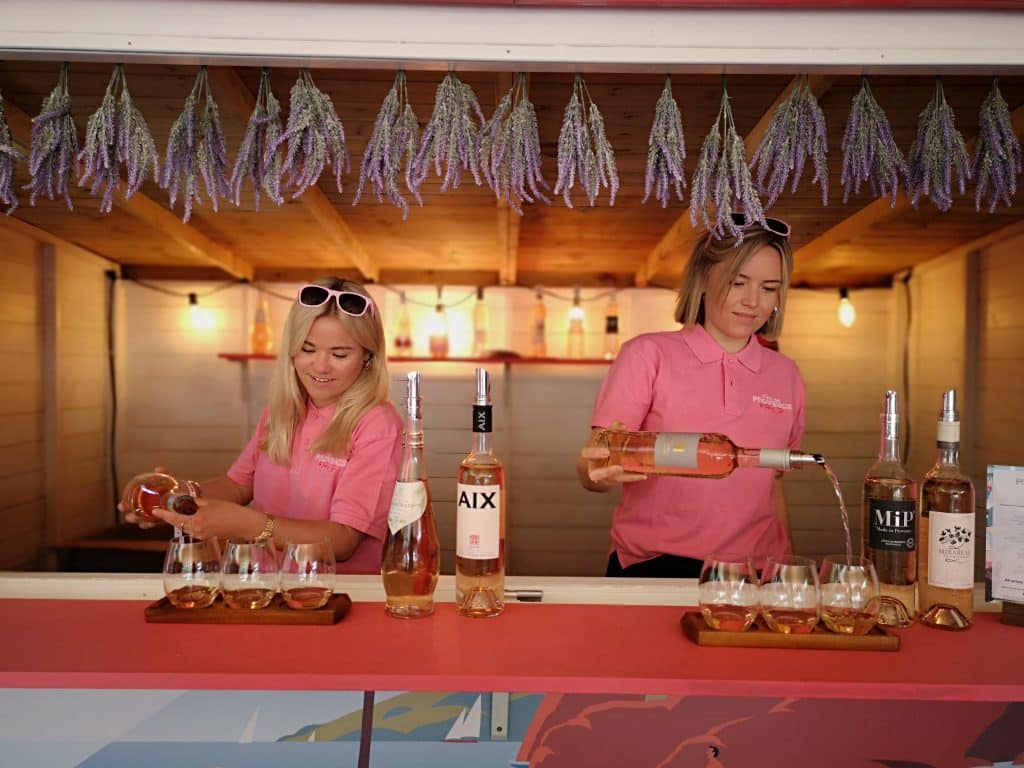 Two women serving wine at bar
